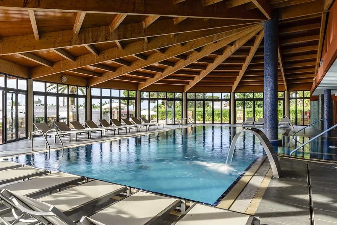 una piscina dentro de un hotel con un techo de madera