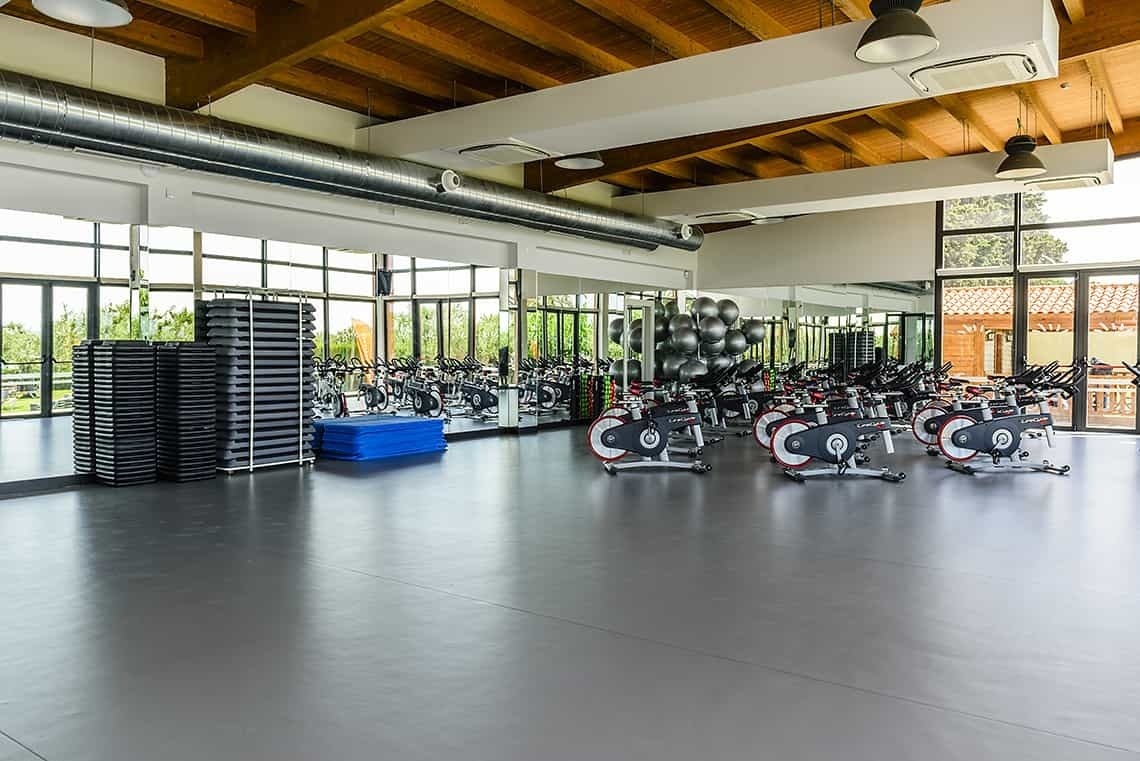 un gimnasio lleno de bicicletas de ejercicio y espejos