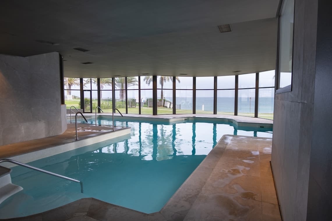 una piscina dentro de un edificio con muchas ventanas