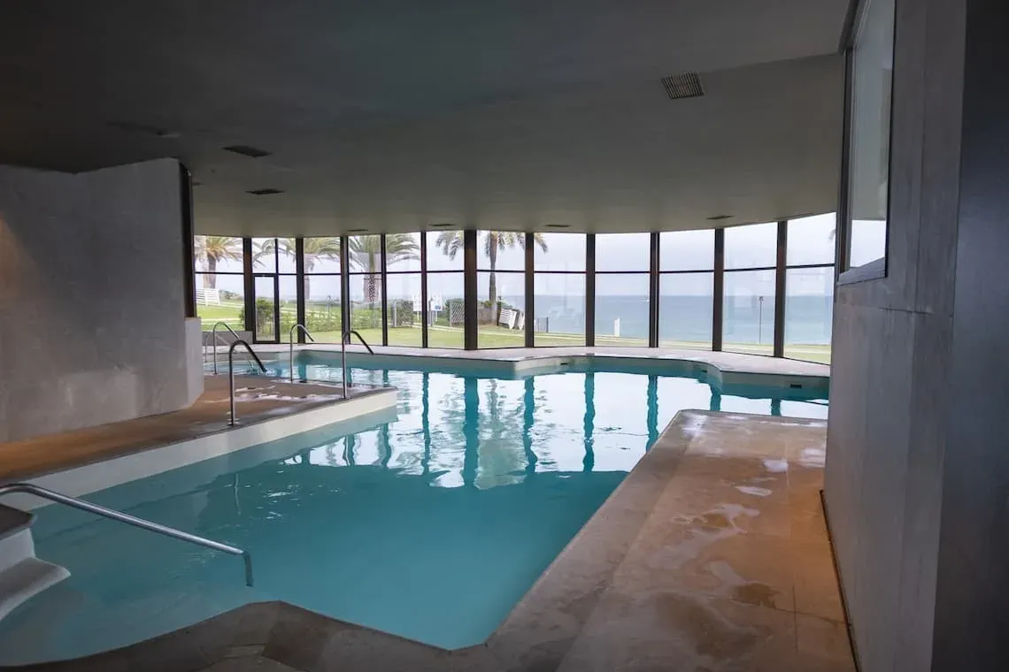 ESTIVAL: Corporate indoor pool with sea views and palm trees.