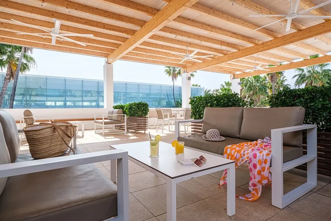 ESTIVAL Corporate terrace with sofas, table, and sea views, perfect for events.
