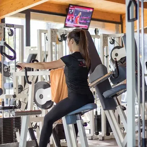 Woman training in a modern gym, perfect for ESTIVAL: corporate retreats.