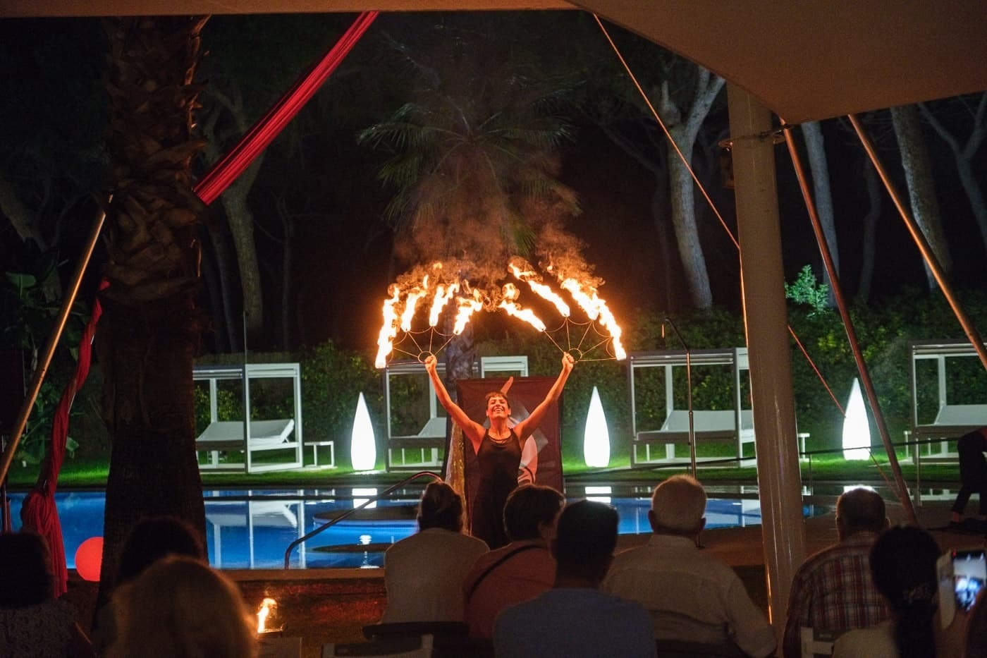 a woman performs a fire show in front of a crowd