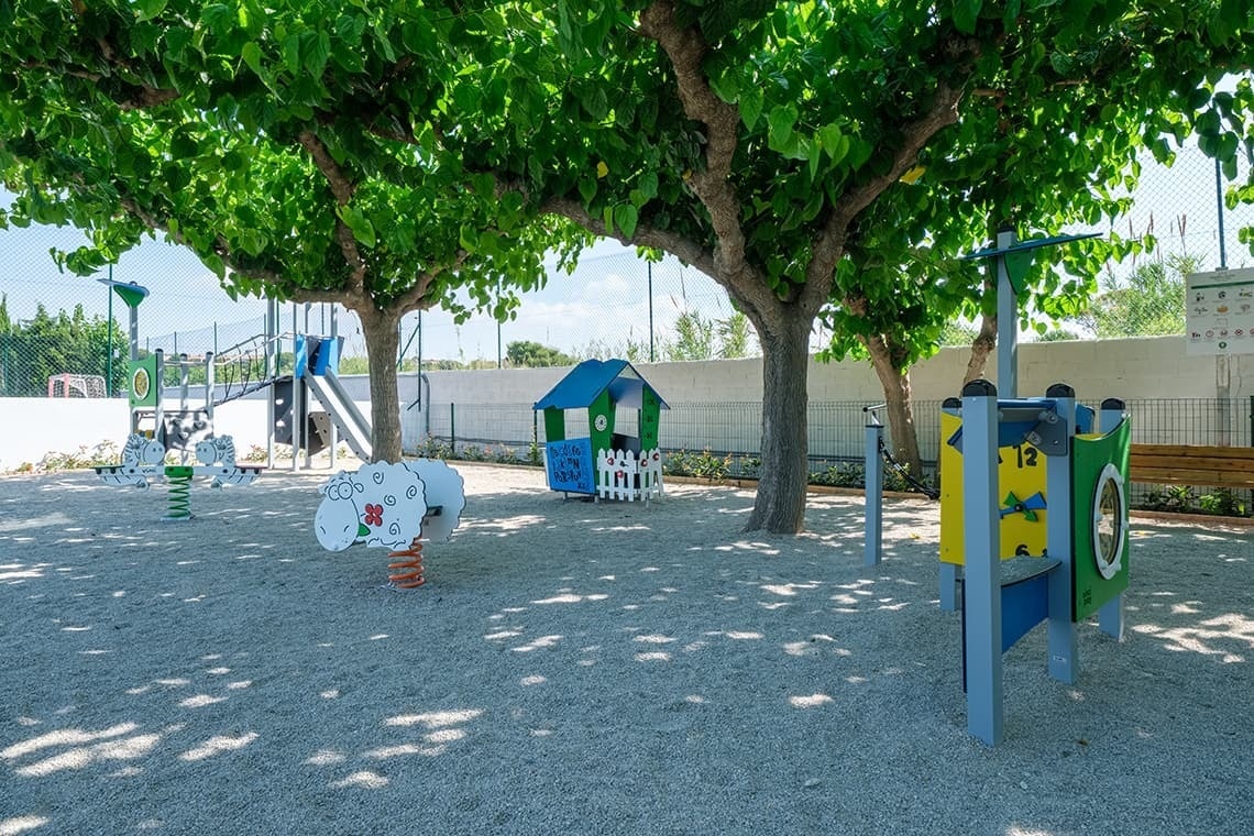 un área de juegos para niños con una casa azul y una oveja amarilla