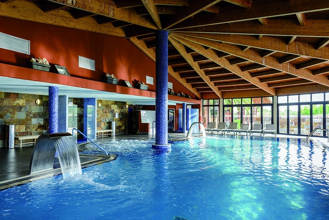 una piscina dentro de un spa con un techo de madera