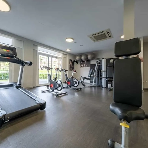 Modern ESTIVAL gym: Corporate with bikes and weights.