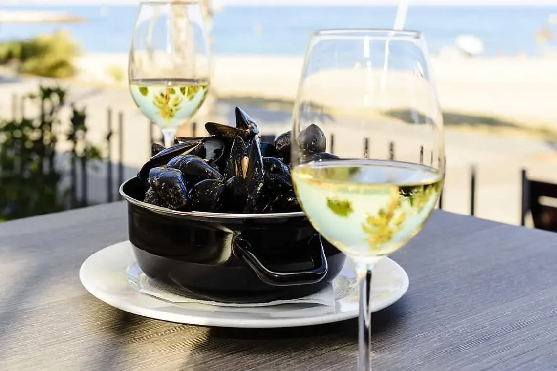 Mariscos y vino blanco en terraza, con vistas al mar. Perfecto para ESTIVAL: Corporativa.
