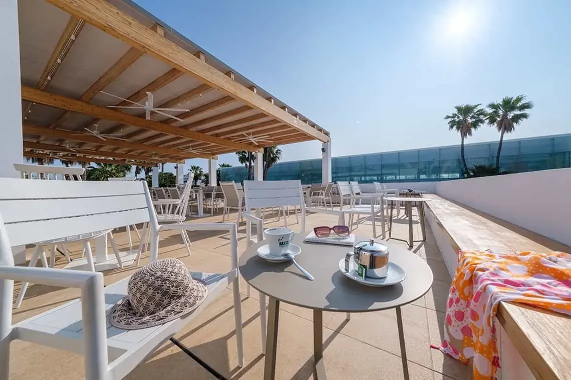 ESTIVAL: Corporate Terrasse mit Kaffee, Hut und Meerblick.