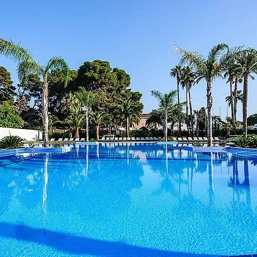 Piscina d'aigua blava turquesa a Estival Eldorado Resort, ideal per relaxar-se amb palmeres.