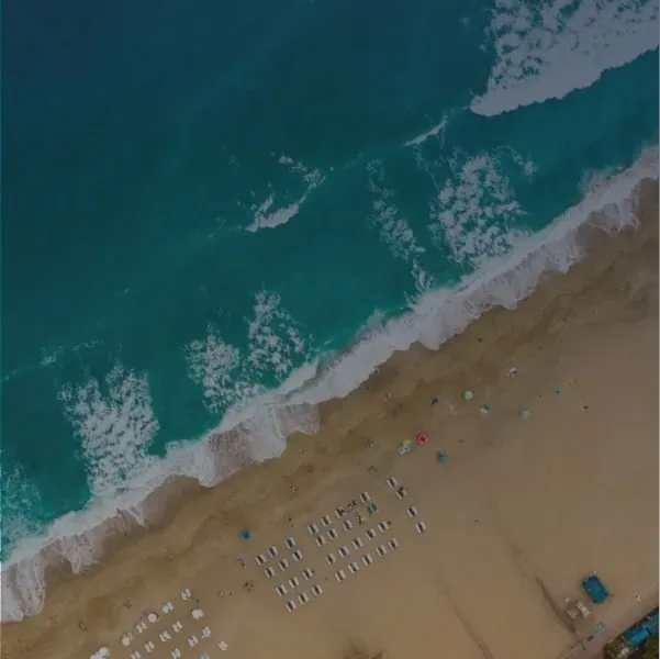 ESTIVAL: Corporativa - Mujer bailando en la playa al atardecer.