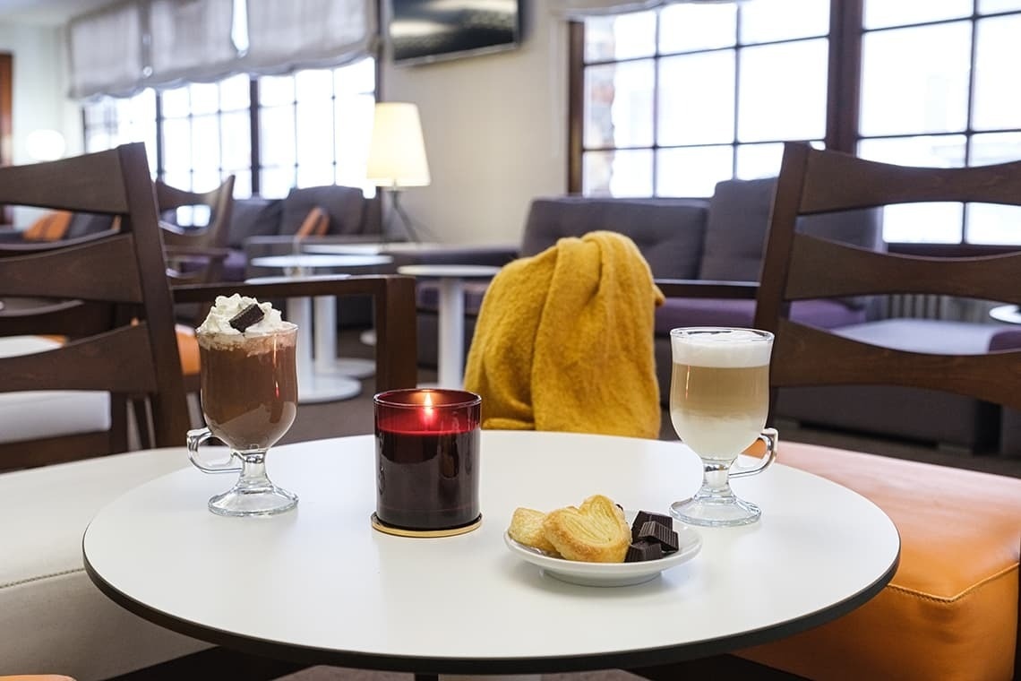 una mesa blanca con dos bebidas y una vela