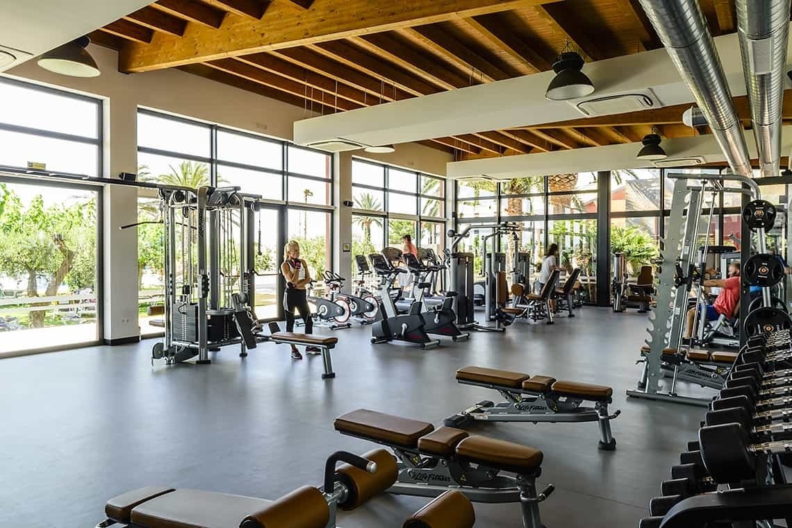 un gimnasio lleno de muchos aparatos y personas