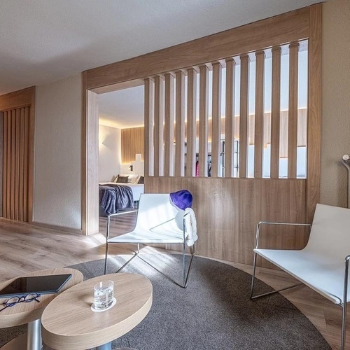 a room with two chairs and a table with a tablet on it