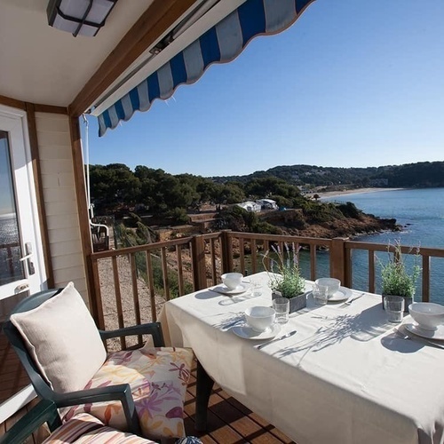 un balcó de fusta amb una mesa i una cadireta