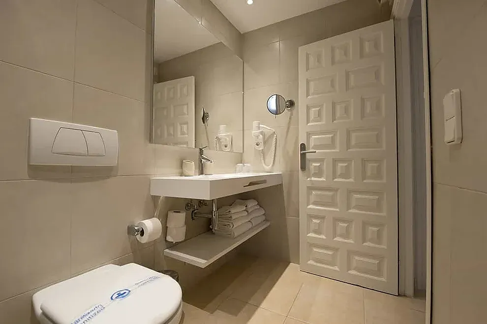 Baño moderno con inodoro y lavabo suspendidos. ESTIVAL: Corporativa.