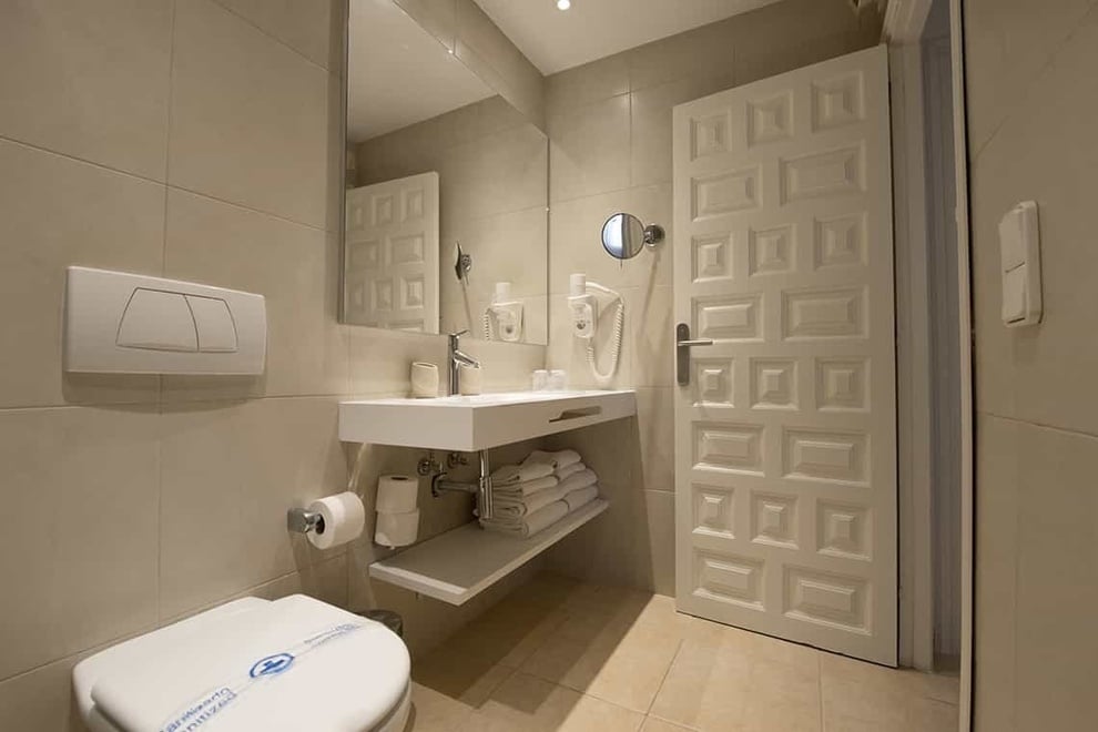 a bathroom with a toilet and a sink with a sticker on the toilet that says ' hygiene ' on it