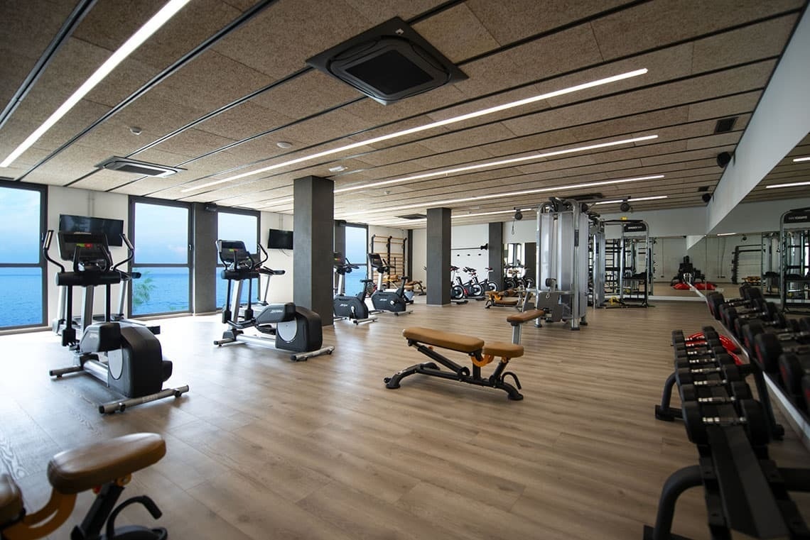 un gimnasio lleno de muchos aparatos de ejercicio y pesas