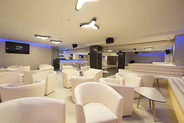 Moderner ESTIVAL: Corporativa Lounge mit weißen Sitzmöbeln und Bar.
