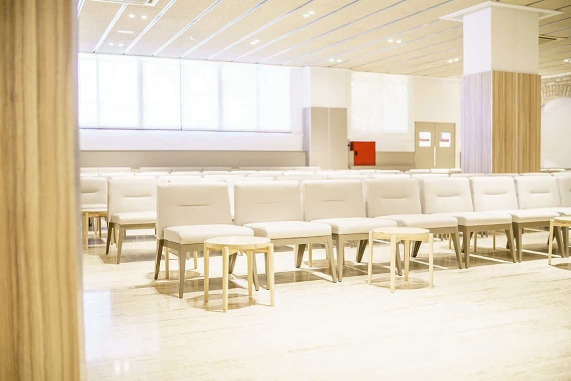 una fila de sillas blancas en una sala de espera