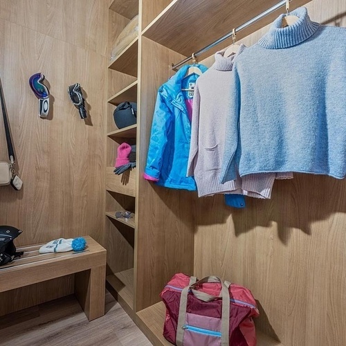 a blue sweater hangs in a wooden closet