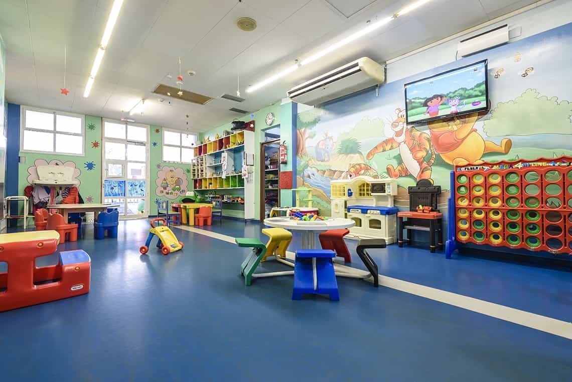 ein Spielzimmer mit einem winnie puuh-Bild an der Wand