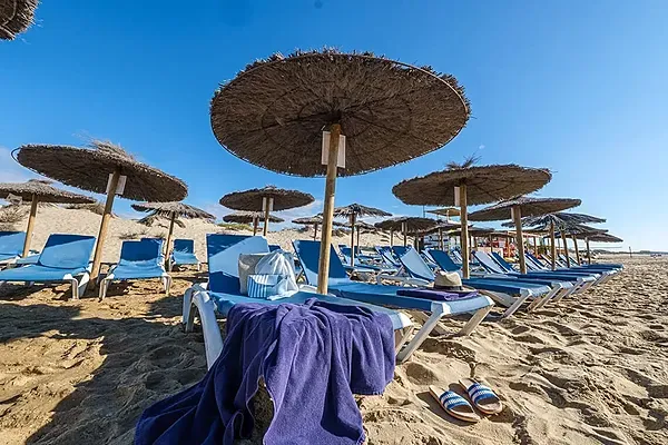 ESTIVAL: Firmenveranstaltung - Liegestühle und Sonnenschirme am goldenen Strand, Meerblick.