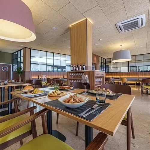 Modern ESTIVAL: Corporativa restaurant with set tables and food.