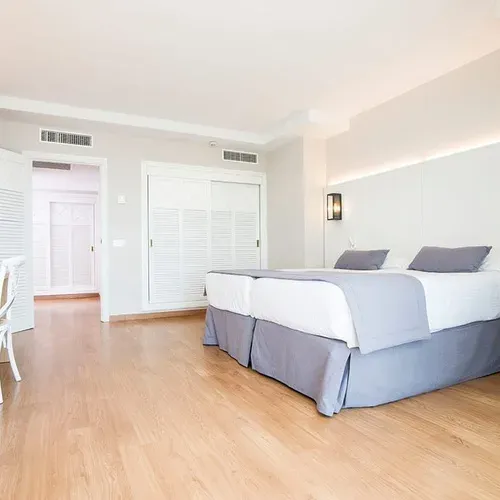Spacious hotel room with two beds and modern amenities at Estival Torrequebrada Benalmádena.