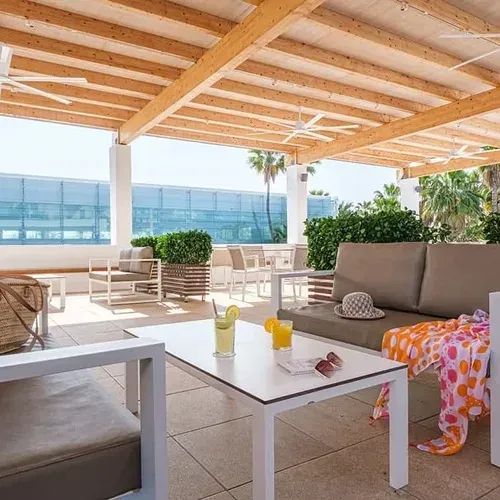 ESTIVAL: Corporate terrace with sofas, table, and outdoor views.