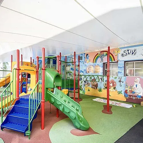 ESTIVAL: Corporativa playground with colorful slides and games under a canopy.