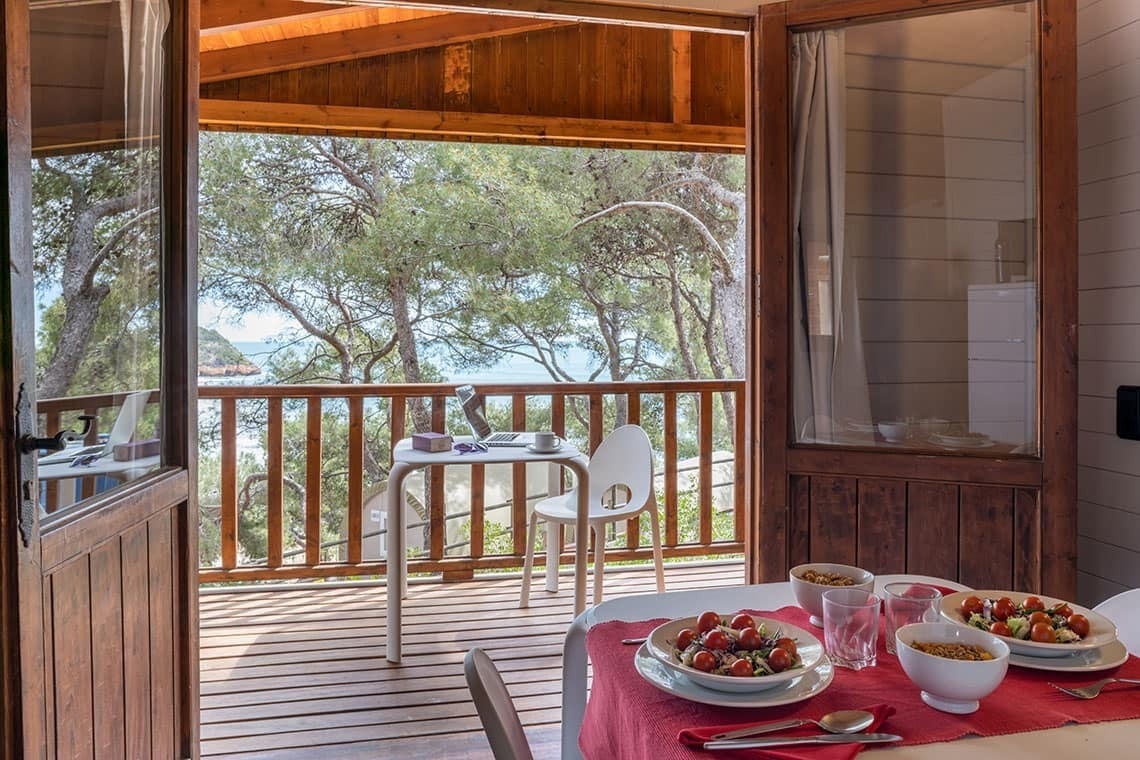 a table with bowls of food on it and a view of the ocean