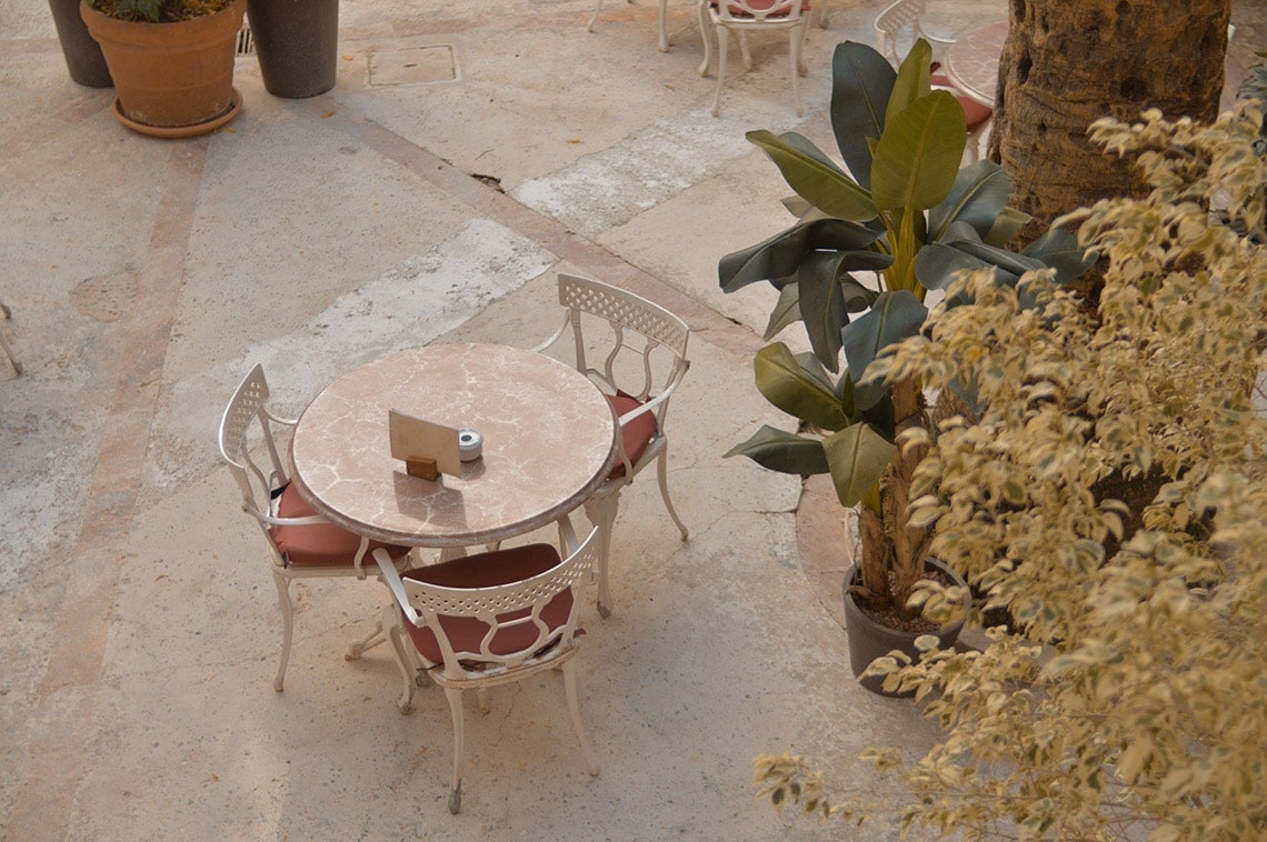 una mesa y sillas en un patio con una planta