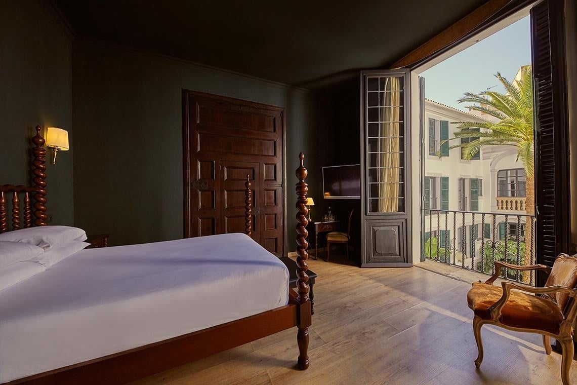 una cama y una silla en una habitación con una ventana abierta
