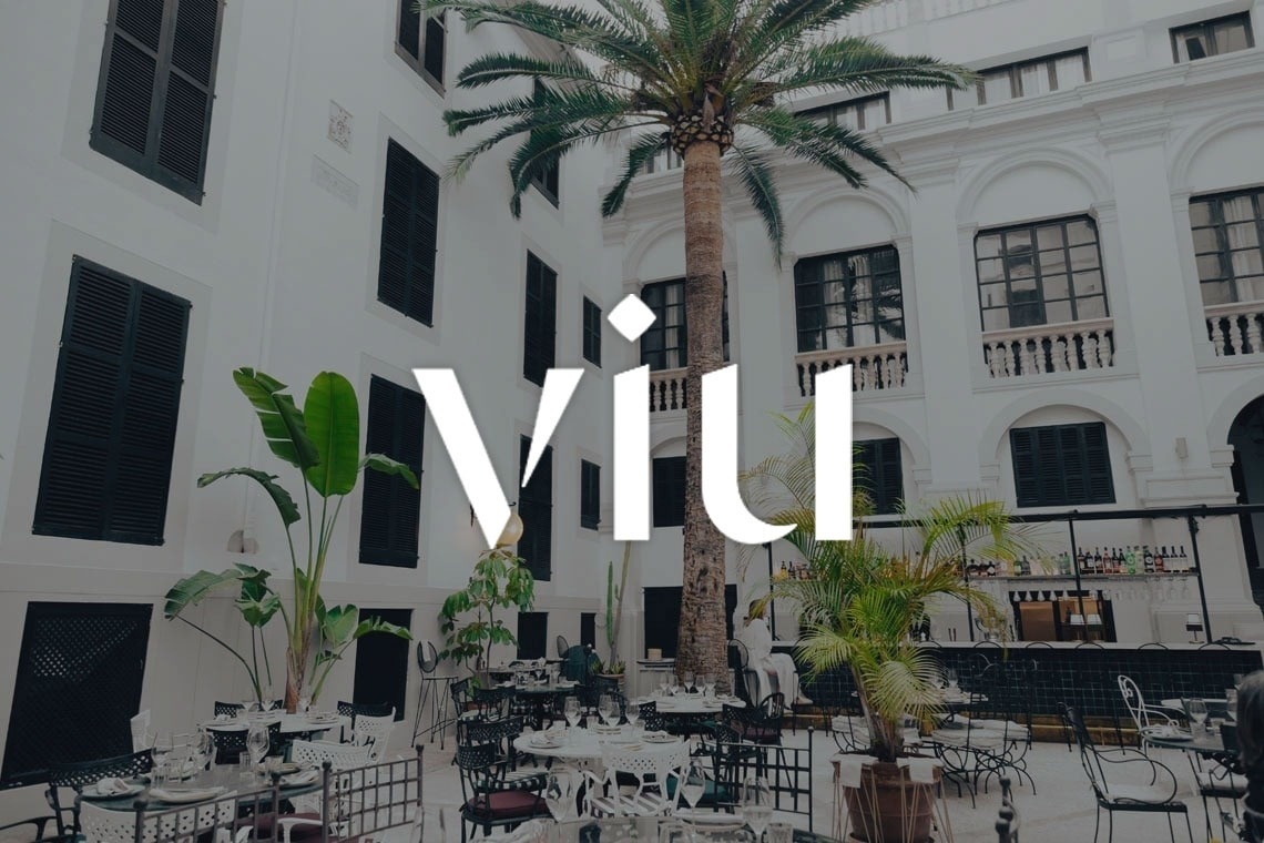 un edificio blanco con una palmera y el logo vil