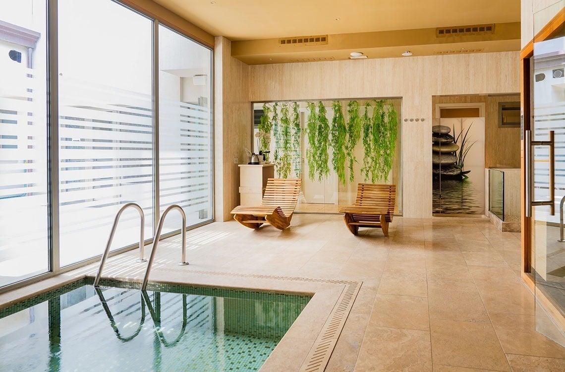 una stanza con una piscina e due sedie in legno