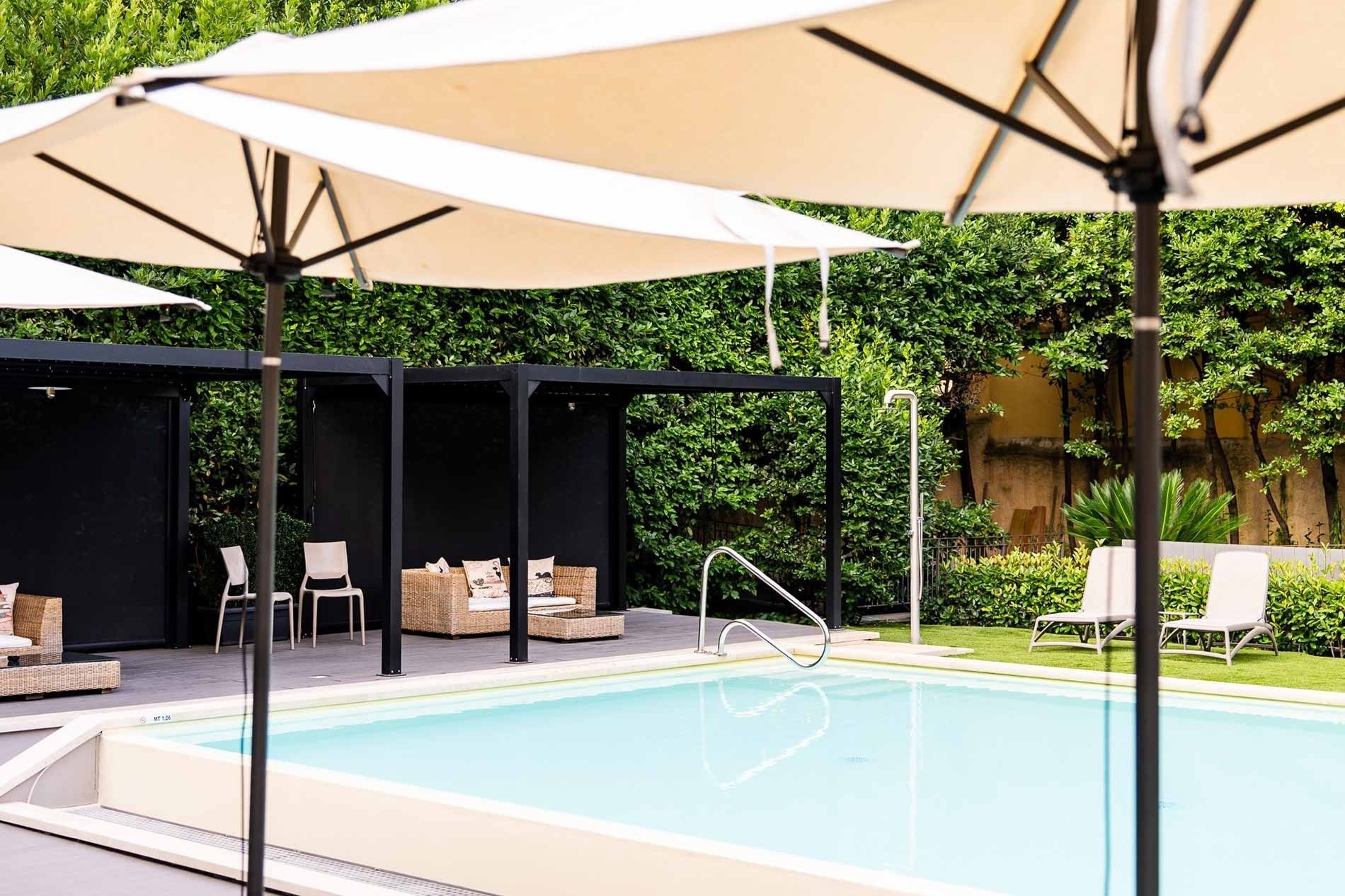 una grande piscina circondata da sedie e ombrelloni