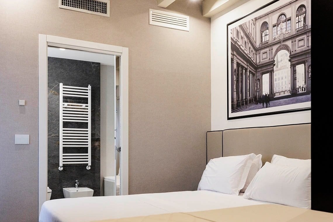 una camera d' albergo con un letto e un dipinto sopra