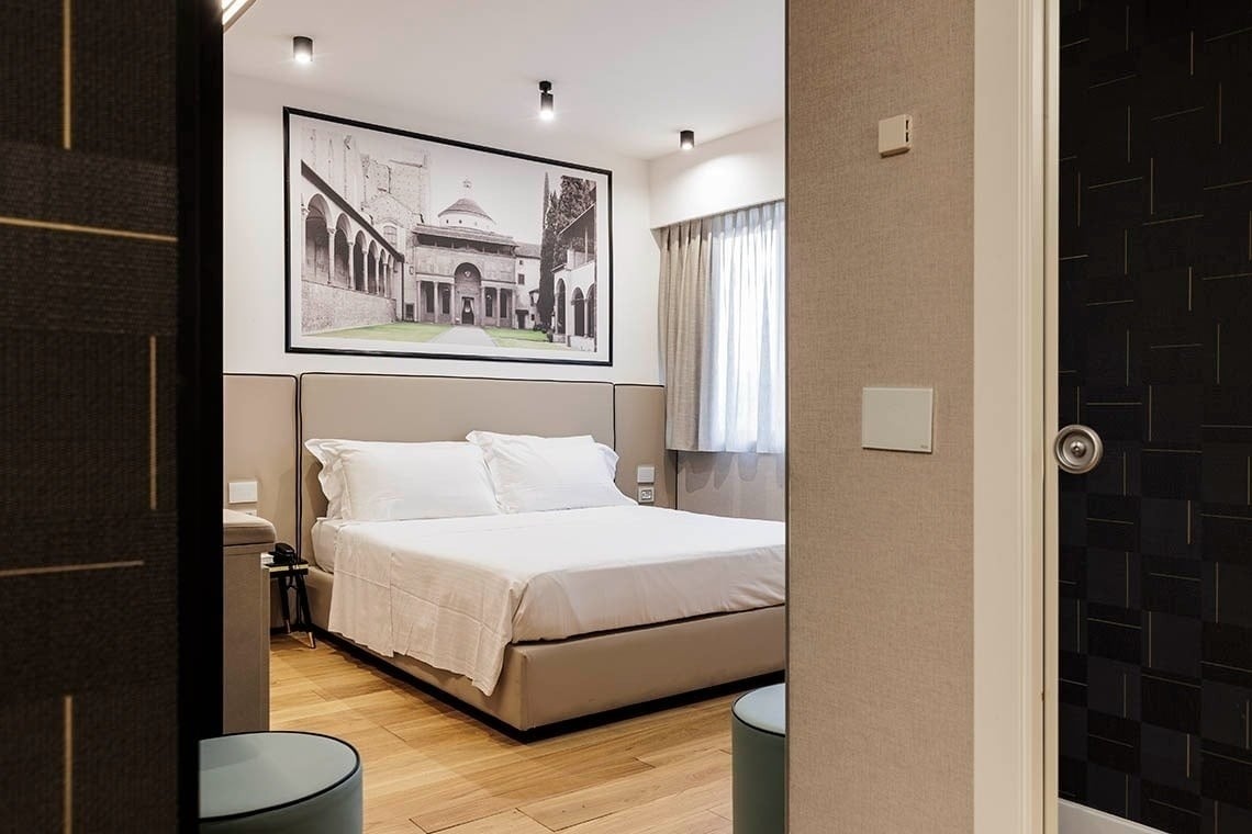 una camera d' albergo con un letto e un dipinto sopra