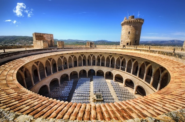 un anfiteatro circular con una torre en el fondo