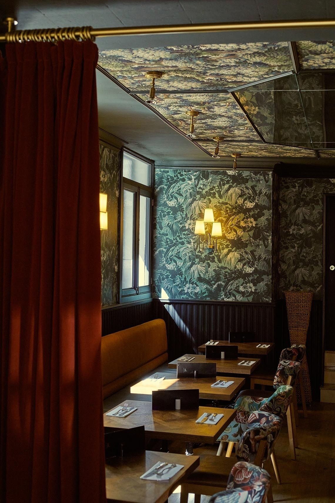 un restaurante con mesas y sillas y una cortina roja