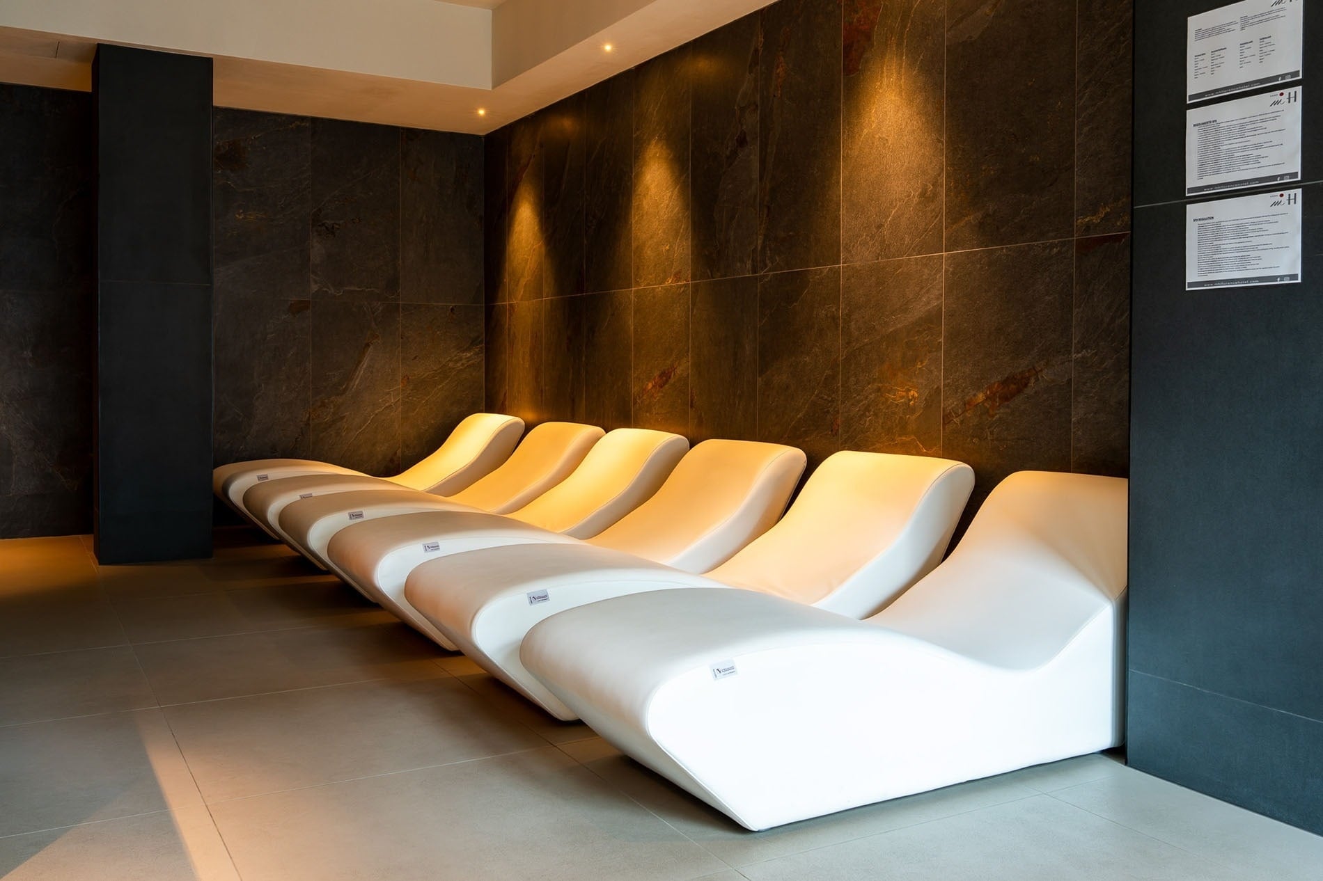 una mujer se sienta en una sauna con luces rojas y azules