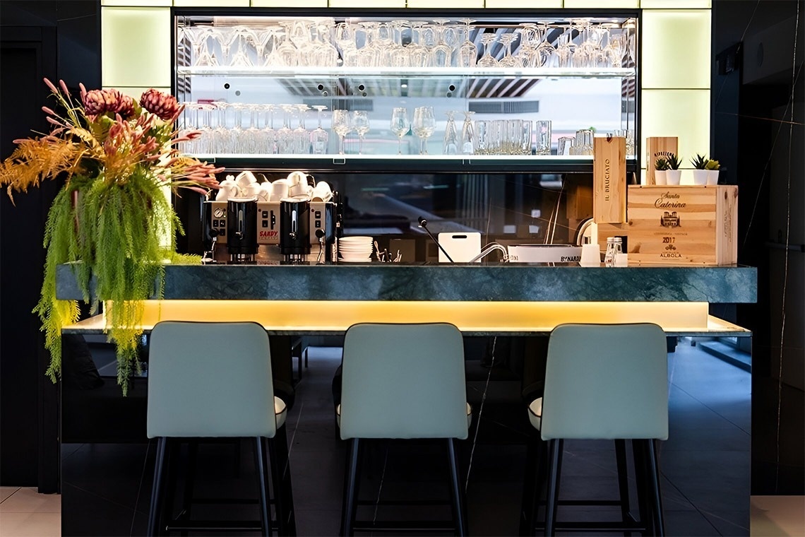 una mesa de madera con comida y una copa de vino