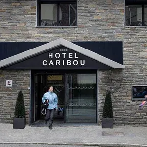 uma mulher caminha em direção à entrada do hotel caribou