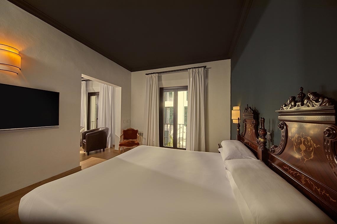 una habitación con una cama y una televisión en la pared