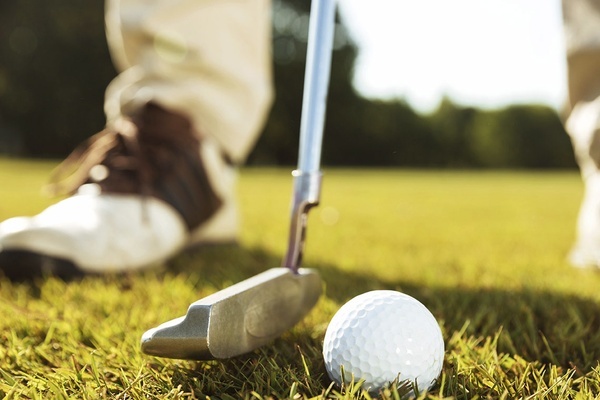 un primer plano de un putter y una pelota de golf