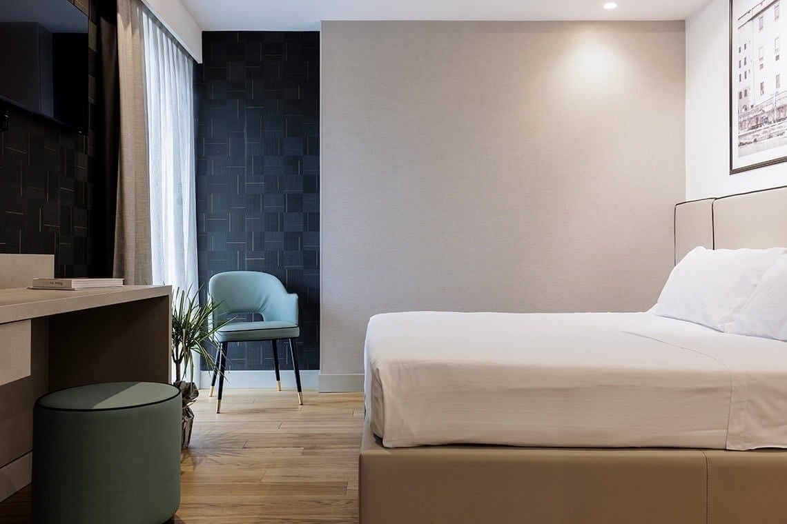 una camera d' albergo con un letto e una sedia