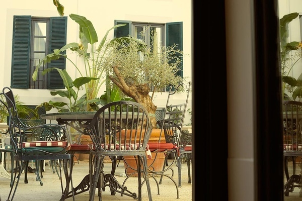 una mesa y sillas en un patio con un árbol en el medio