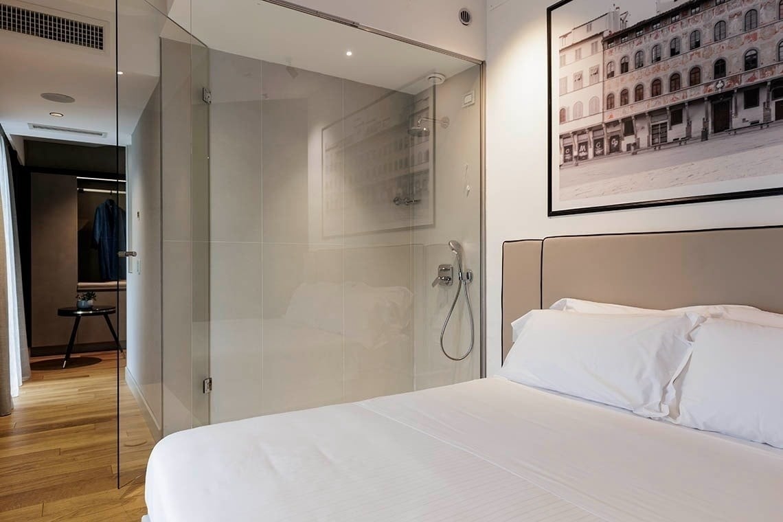 una camera d' albergo con un letto , un divano , un tavolo e un vassoio di cibo .