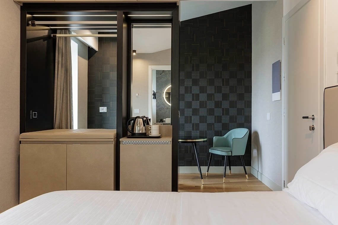 una camera d' albergo con un letto , un divano , un tavolo e un vassoio di cibo .