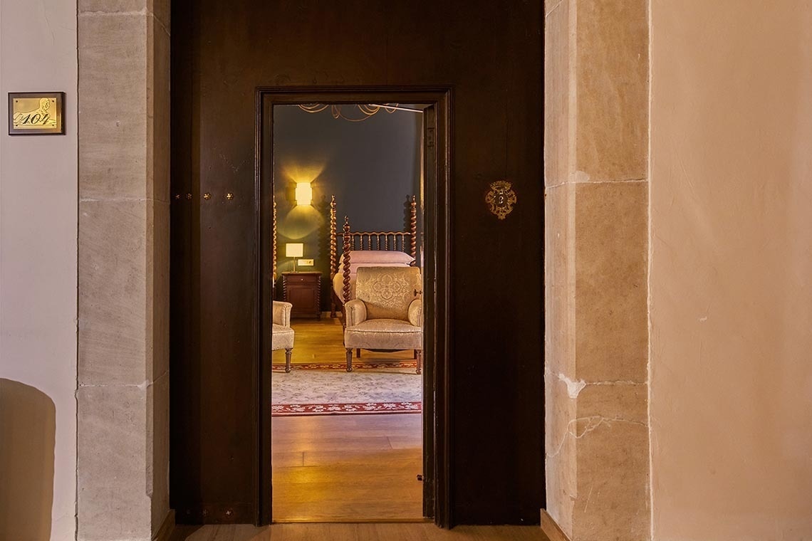 una puerta que conduce a una habitación con una cama y una silla